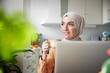 © Johnér - Smiling woman with hijab having coffee