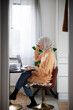 © Johnér - View of woman with hijab working from home using laptop