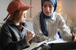 © Johnér - Mother wearing hijab helping son doing homework