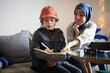 © Johnér - Mother wearing hijab helping son doing homework