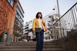© Johnér - Low angle view of woman walking down stairs and carrying skateboard