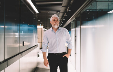 Sticker - Senior man standing in corridor of modern building