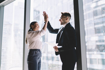 Wall Mural - Cheerful multiethnic colleagues giving high five