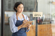© David - Startup successful small business owner sme beauty girl stand with tablet smartphone in coffee shop restaurant. Portrait of asian tan woman barista cafe owner. SME entrepreneur seller business concept