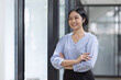 © David - Young asian woman, professional entrepreneur standing in office clothing, smiling and looking confident, workplace office background