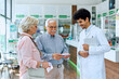 © Drazen - Senior man and his wife choosing vitamins with help of pharmacist in drugstore.