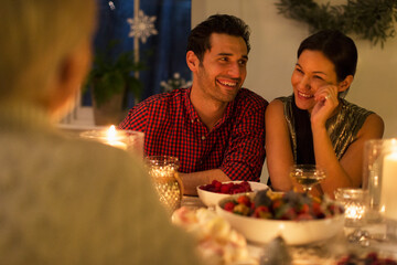 Wall Mural - Smiling couple enjoying candlelight Christmas dinner