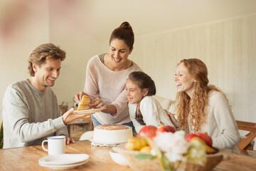 Canvas Print - Woman serving cake to family at dining table