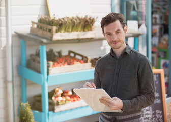 Poster - Portrait smiling farmer's market worker with clipboard