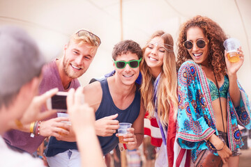 Wall Mural - Young friends with beer posing for camera phone at music festival