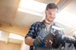 © KOTO - Smiling metal worker using sander in workshop