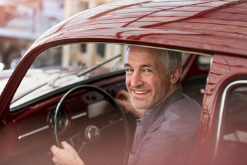 Wall Mural - Portrait smiling mechanic inside classic car