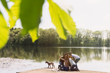 Canvas Print - Friends with camera phone taking selfie on sunny lakeside dock