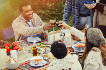 Wall Mural - Couple toasting wine glasses at patio table lunch