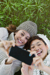Wall Mural - Overhead view smiling women taking selfie with camera phone in grass