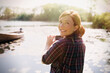 © KOTO - Portrait smiling woman red hair photographing sunny lake camera phone