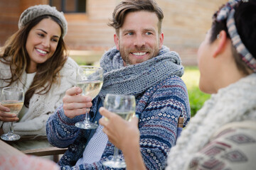 Canvas Print - Smiling friends drinking wine on patio