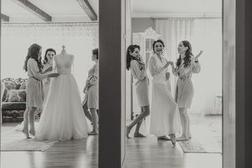 bride's girlfriend prepares the bride for her wedding day. The bride's girlfriend helps secure the bride's wedding dress before the ceremony.