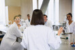 © KOTO - Female college student leading study group in science laboratory classroom