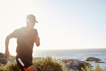 Wall Mural - Male triathlete runner running along ocean