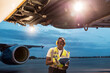 © KOTO - Airport ground crew worker with clipboard under airplane on tarmac