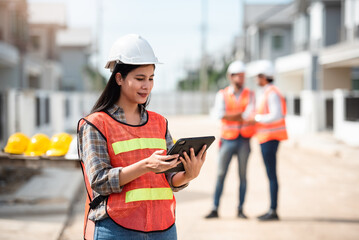 Construction worker, Engineering or architect woman using digital tablet for work at construction site , Engineer female inspection at real estate project.