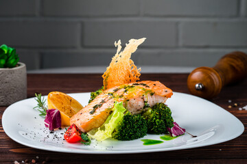 Wall Mural - Salmon steak with broccoli, tomatoes, lettuce and herbs, diet food.