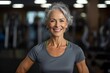 © igolaizola - Portrait of smiling senior woman exercising in fitness studio at the gym
