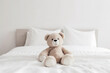 Cute little teddy bear sitting alone on white bed in morning, generative ai.