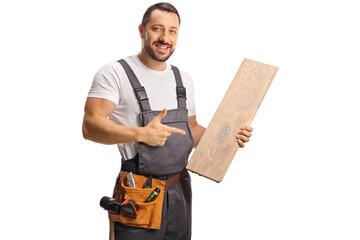 Wall Mural - Carpenter holding a wooden floor beam and pointing