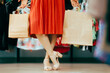 Shopping Woman Walking in a Store Wearing Elegant Sandals .Elegant fashionista carrying her shopping bags in fashion boutique
