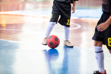 Wall Mural - Kid futsal player control the ball for shoot to goal. Indoor soccer sports hall.