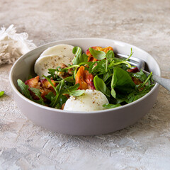 Wall Mural - bowl with salad with peaches, arugula and mozzarella on the table