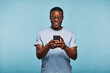 © Flamingo Images - Laughing African man texting on his phone