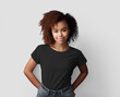 Black t-shirt mockup on an african american woman with curly hair, hands behind her back, empty shirt for design, front.