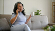 © bongkarn - A happy retired Asian woman enjoys her morning coffee and talking on the phone