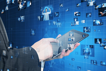 Wall Mural - Close up of businessman hand pointing at tablet. Connecting businesspeople, technology, metaverse and video conference concept. Creative images connected on blurry blue background.