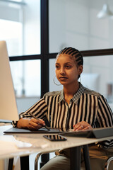 Aufkleber - Young serious female designer with stylus and touchpad looking at computer screen and drawing graphic pictures while sitting by desk