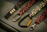 Fototapeta Dmuchawce - Different paracord lanyards keyrings and carabiners on khaki fabric
