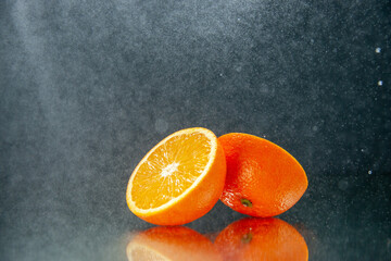 Side view of cut fresh oranges standing side by side on light on black background with free space