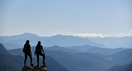 Wall Mural - Two Adventurers Watching the Spectacular View from the Peak