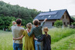 © Halfpoint - Rear view of family near their house with solar panels. Alternative energy, saving resources and sustainable lifestyle concept.