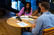 © WavebreakMediaMicro - Diverse male and female colleagues in discussion using tablet in casual office meeting