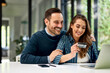 © bnenin - A happy couple using a laptop for online shopping, holding a credit card.
