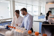 © ReeldealHD images - Scientists discussing data in busy pharmaceutical laboratory