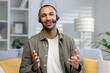 © Tetiana - Portrait of a young African-American man wearing a headset sitting in front of the camera and talking on a video call, conducting online business training, remote consulting