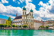 Beautiful view of the Lucerne Jesuit Church St. Francis Xavier at the river Reuss with turquoise water and a blue sky. It is the first large Baroque church built in Switzerland north of the Alps. 
