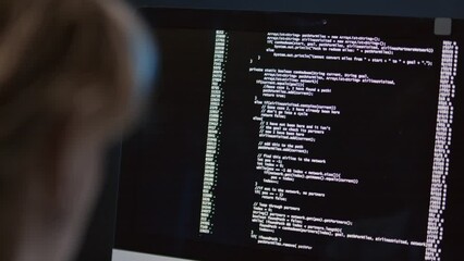 Wall Mural - close up of unrecognizable female programmer sitting at desk looking at computer screen observing co