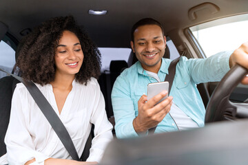 Wall Mural - Young mixed couple having car trip using application on phone