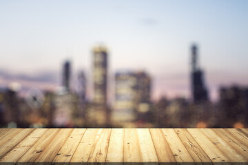 Wall Mural - Table top made of wooden dies with blurry city view at dusk on background, template